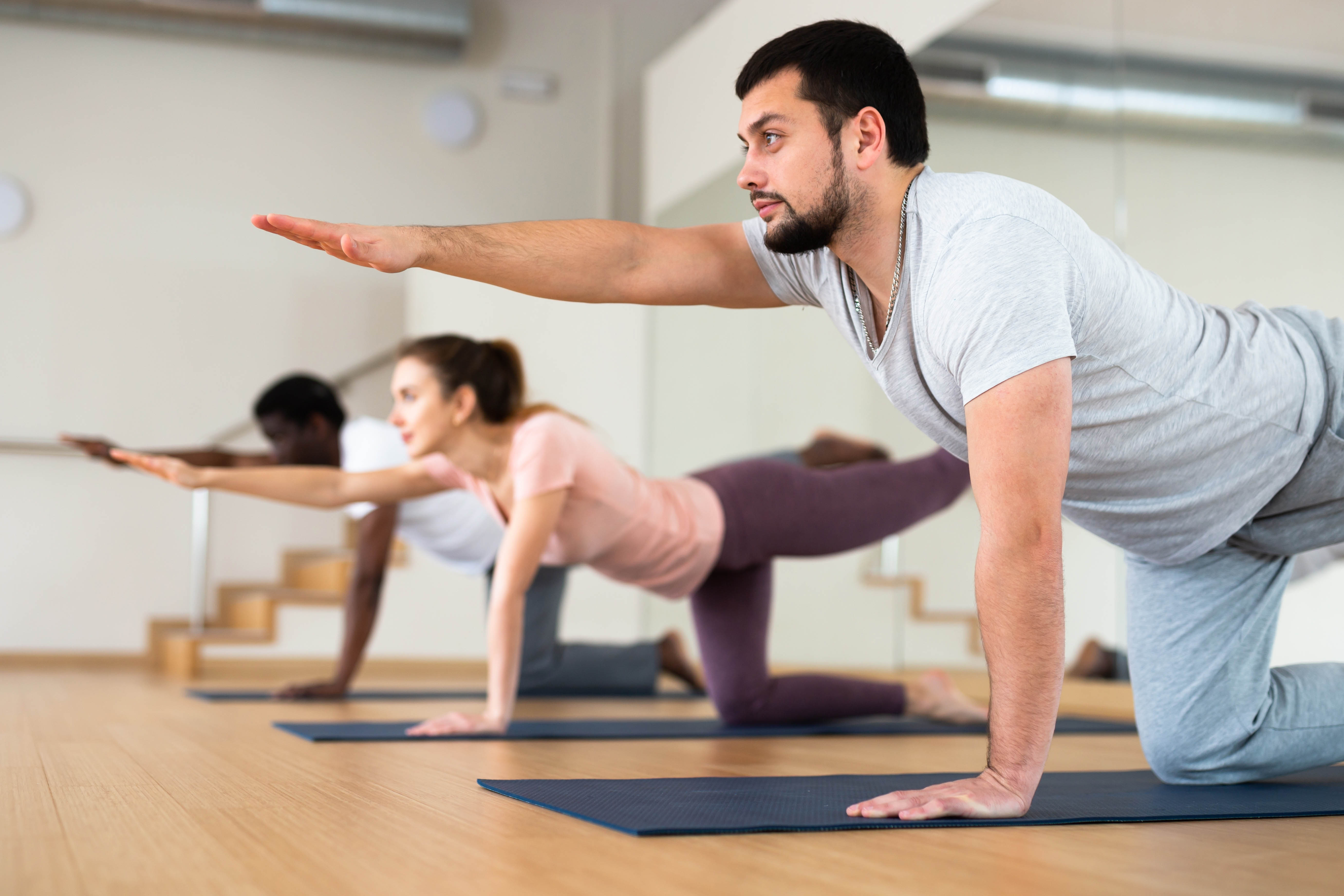 Man and woman stretching in a group yoga workout class Man and woman stretching in a group yoga workout class